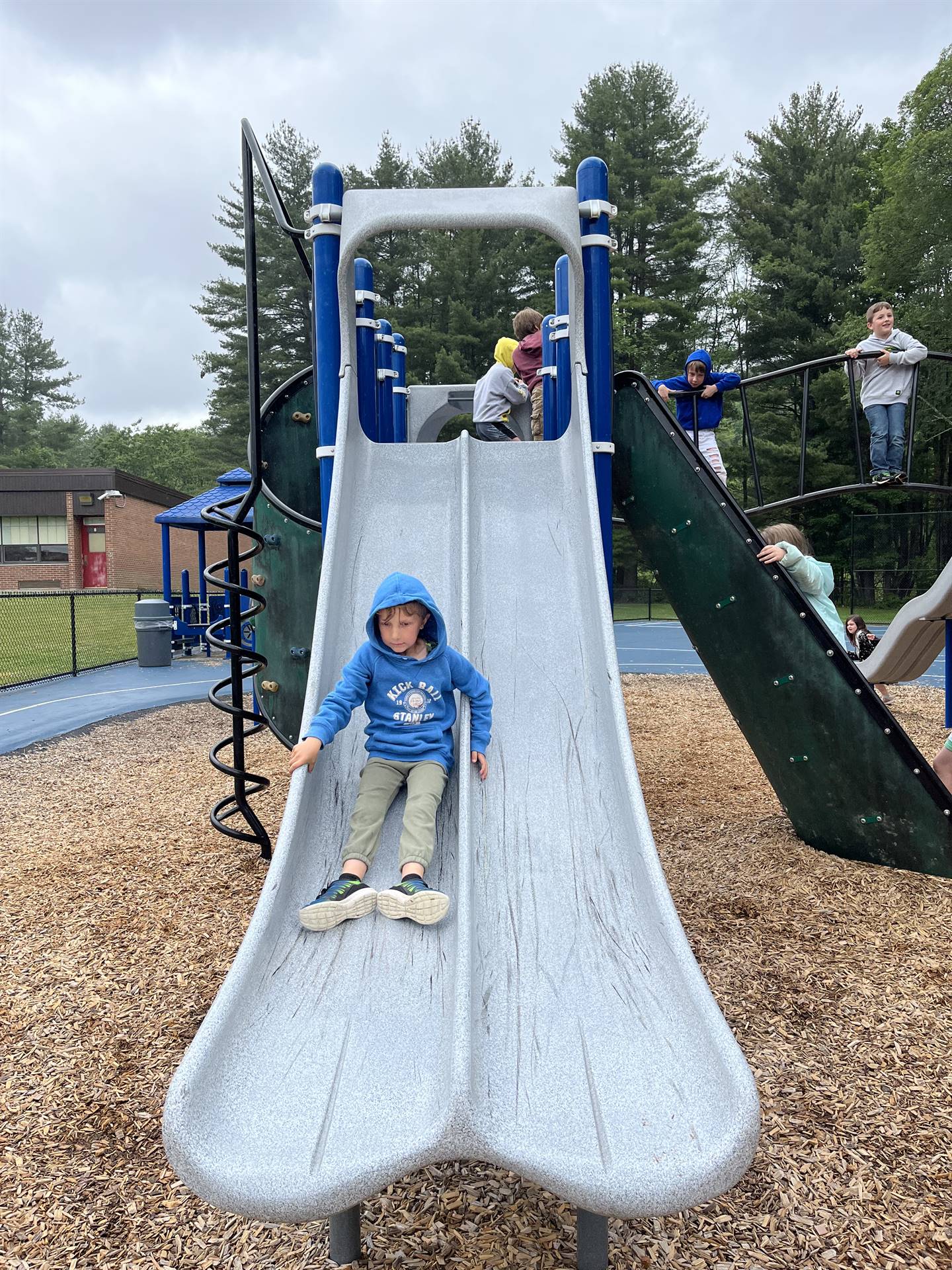 student sliding down slide