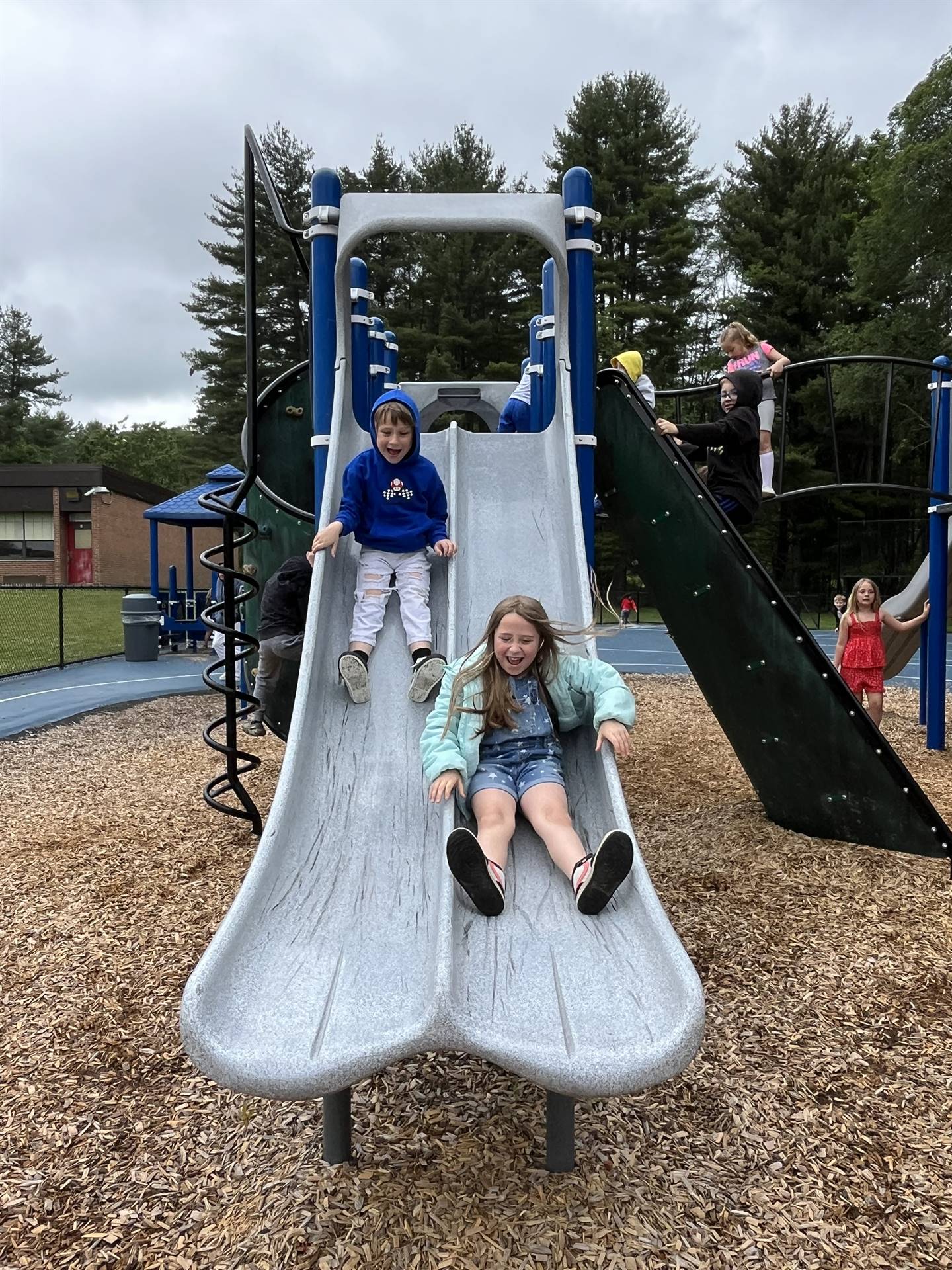 2 students sliding down slide