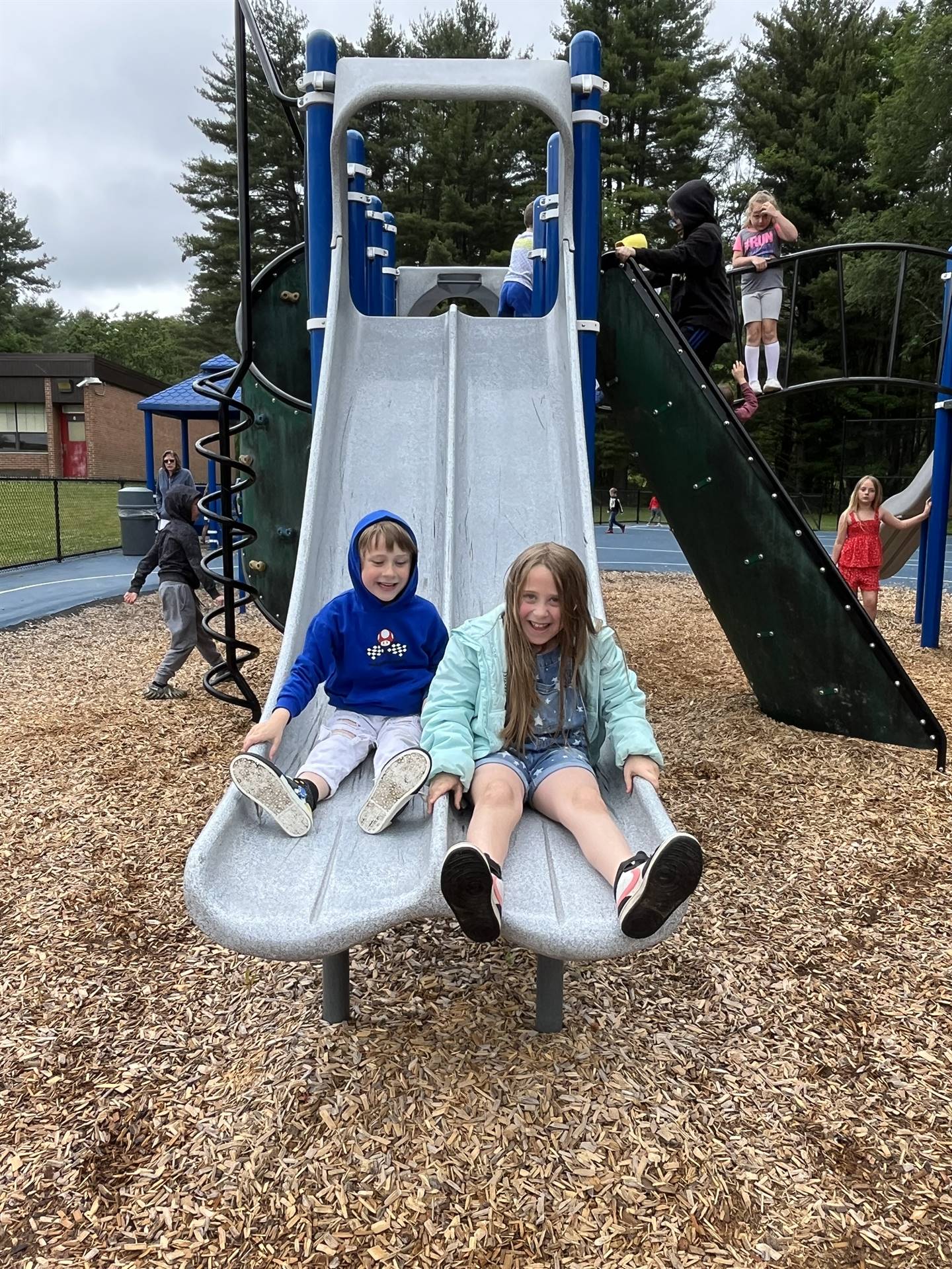 2 students sliding down slide