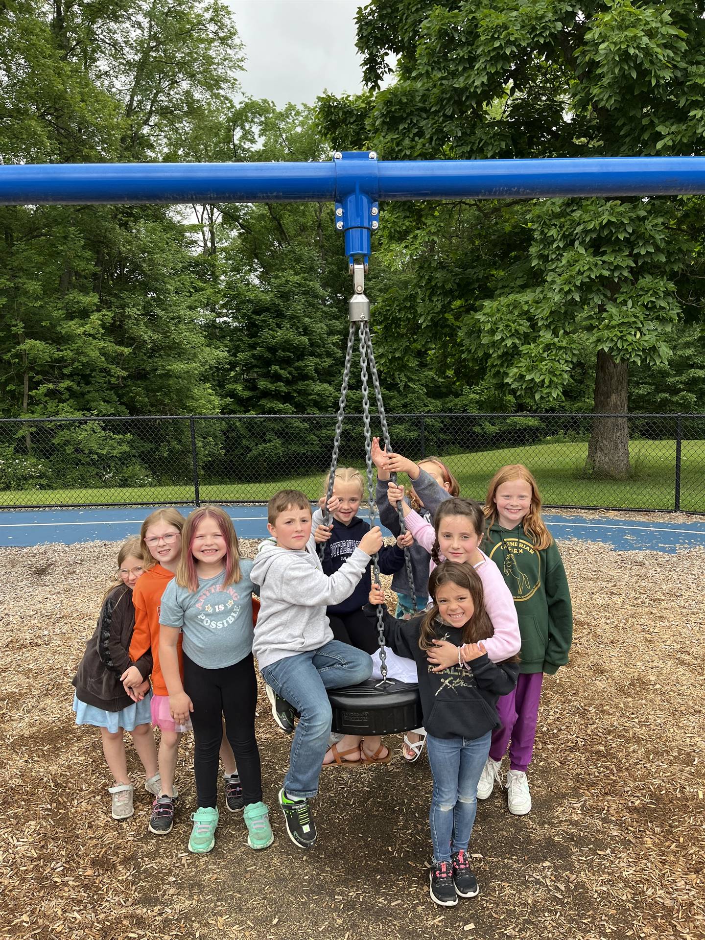 a group of students on the playground tire swing