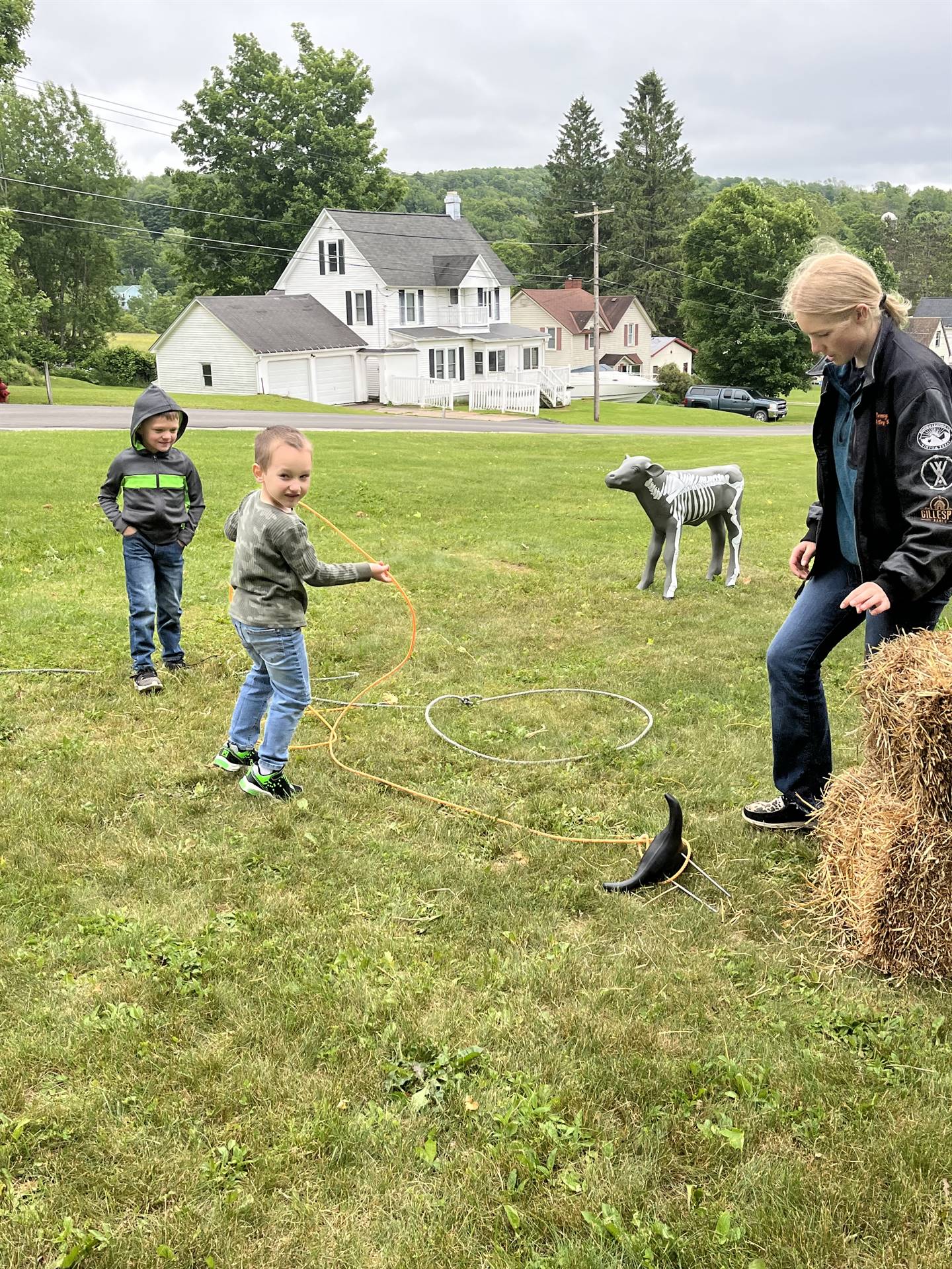 students pretending to lasso a cow statue