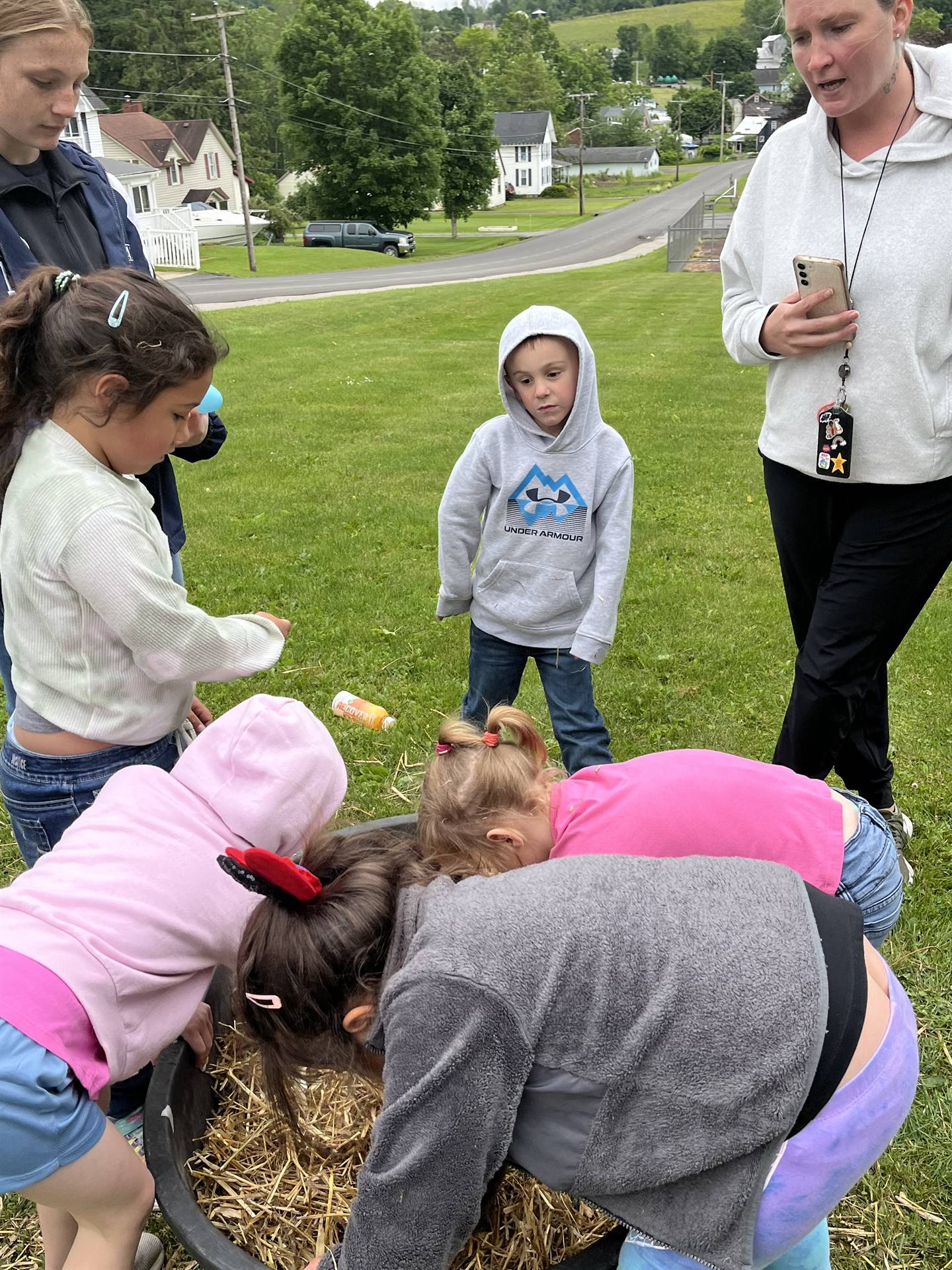 students digging for eggs found in a tub of straw.