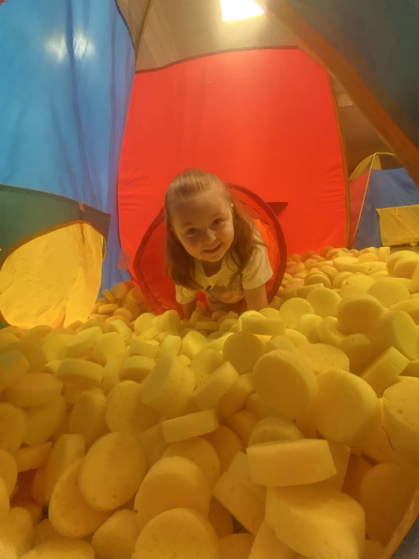 student in yellow ball pit