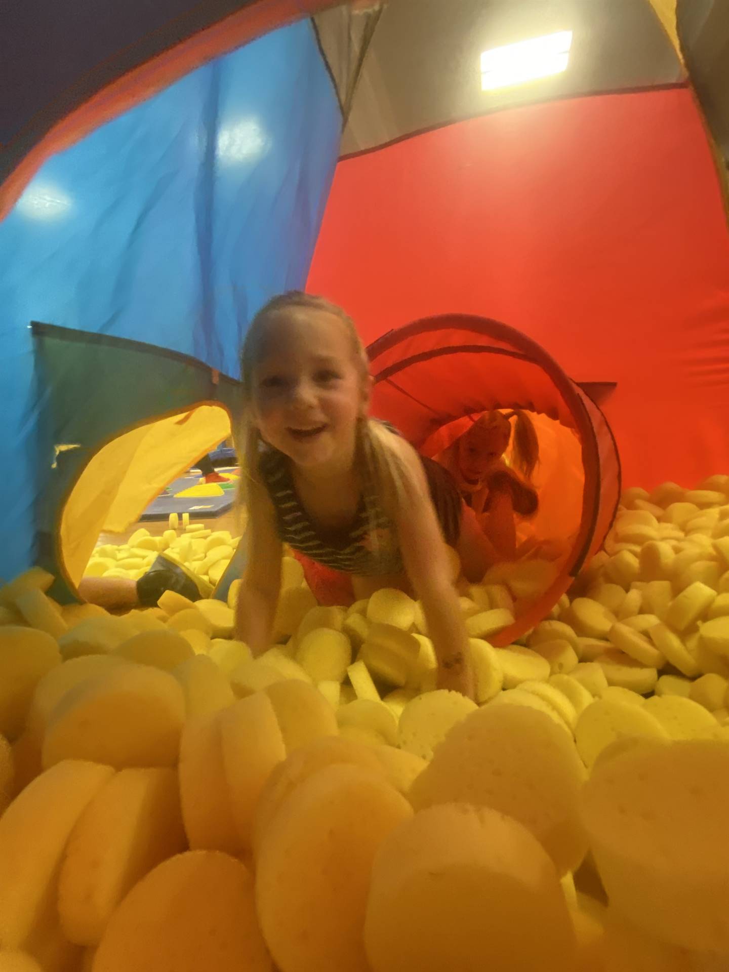 student in yellow ball pit