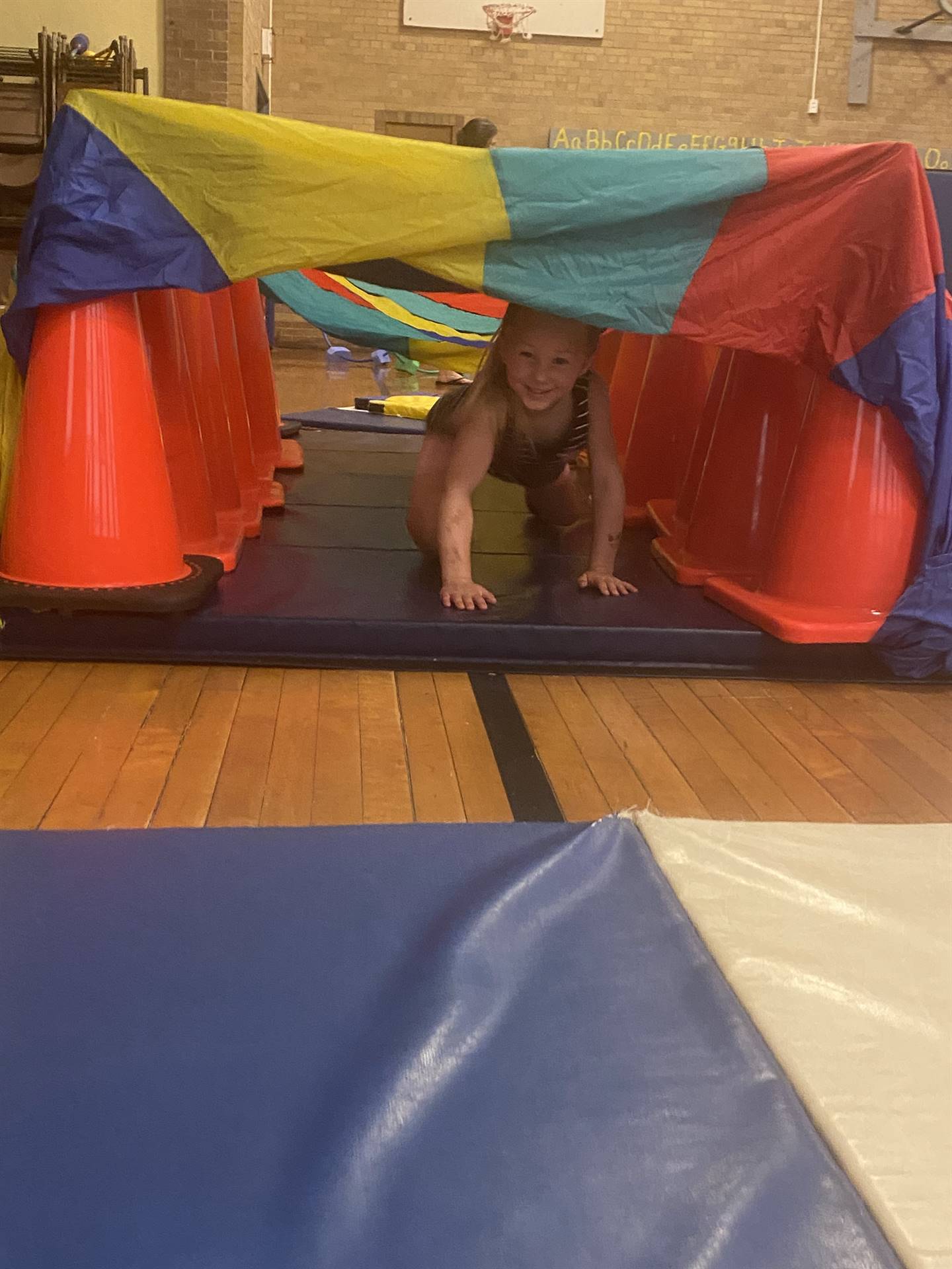 student crawling under tunnel