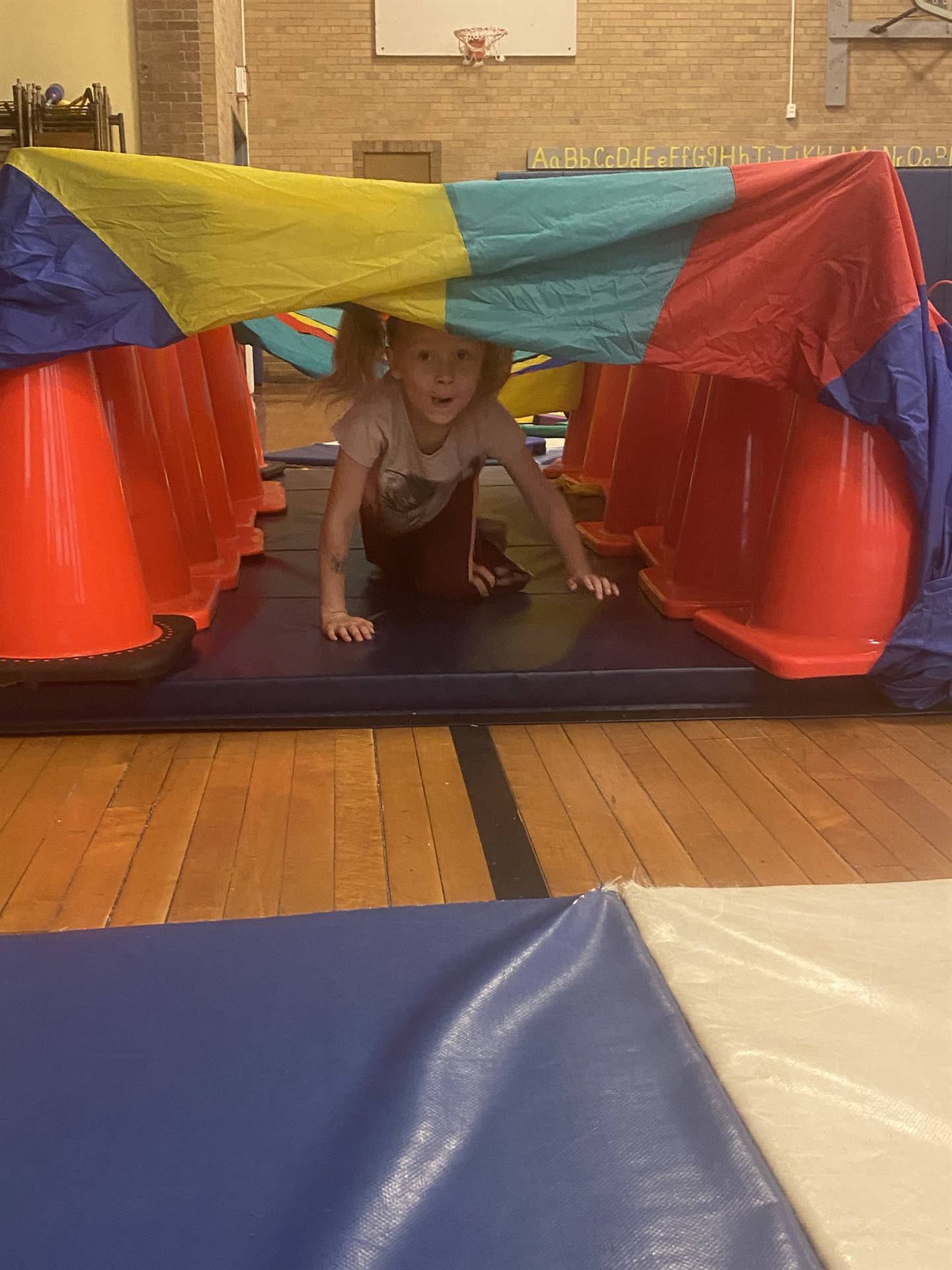 student crawling under tunnel