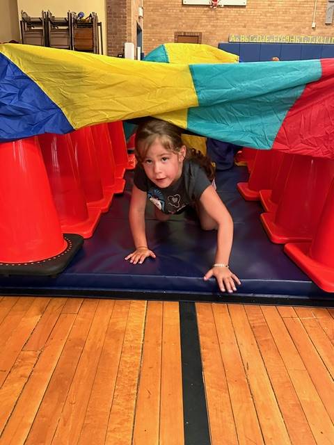 student crawling through tunnel