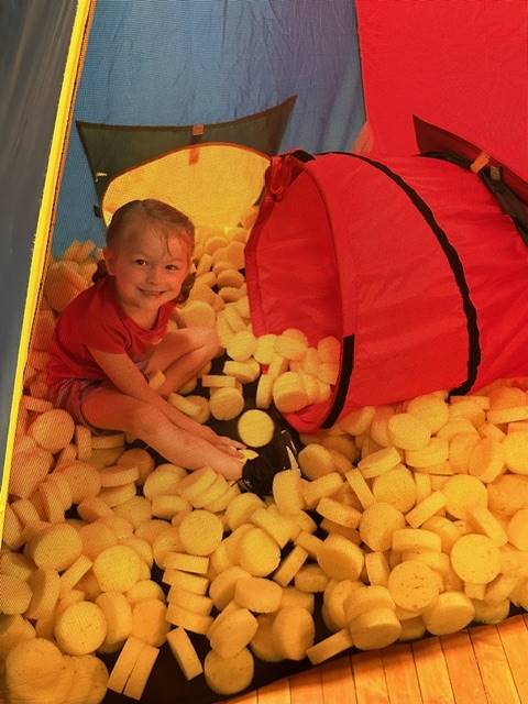 student in tunnel in yellow balls