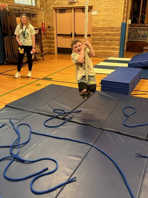 student swinging on rope