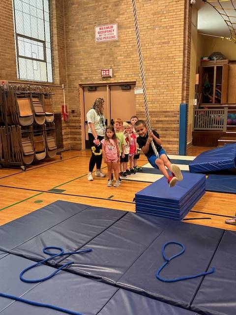 student swinging on rope