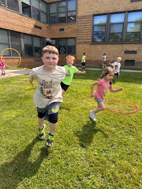 students walking around hula hoops