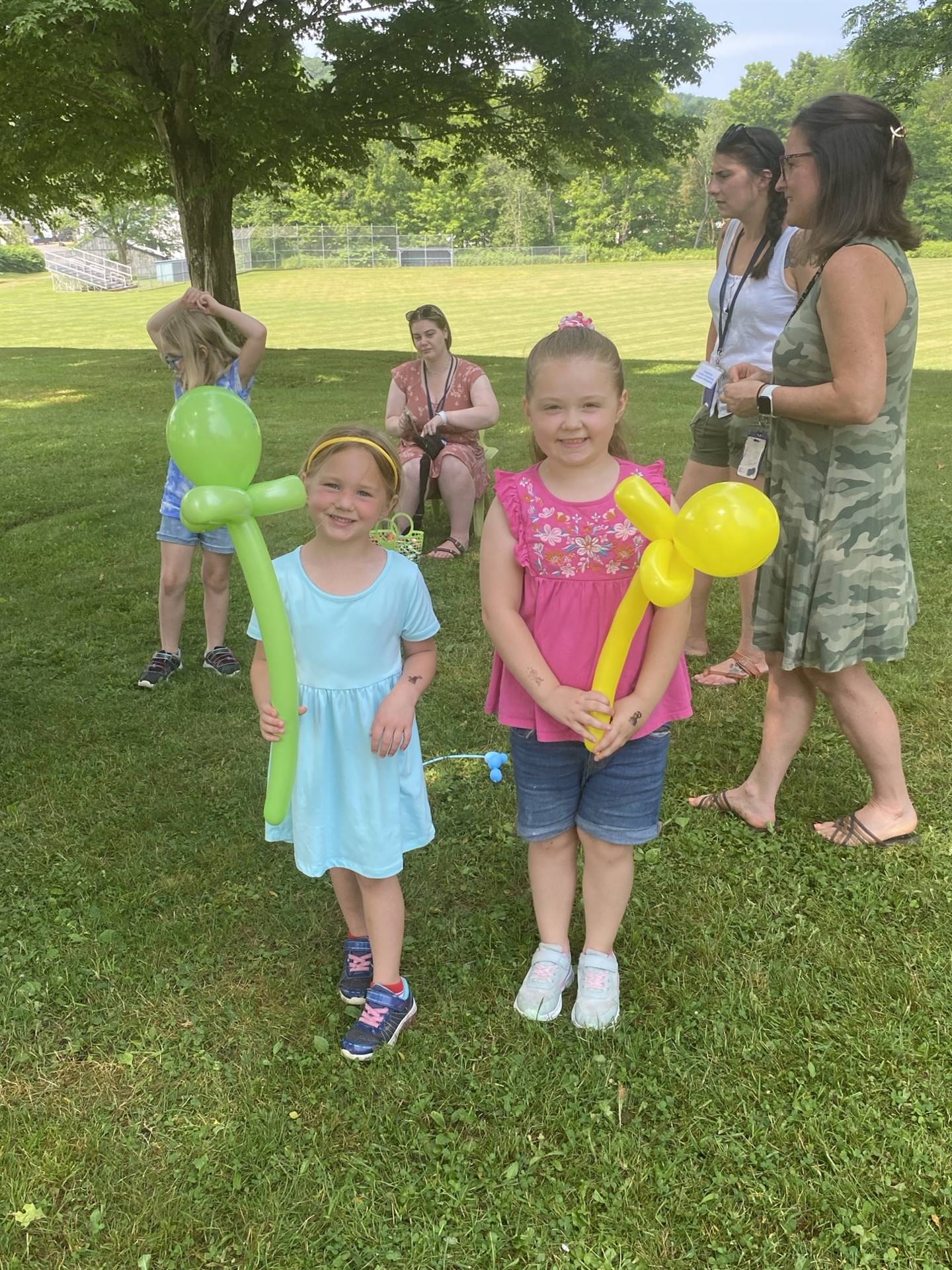 a couple of students show off their balloons from the balloon artist.