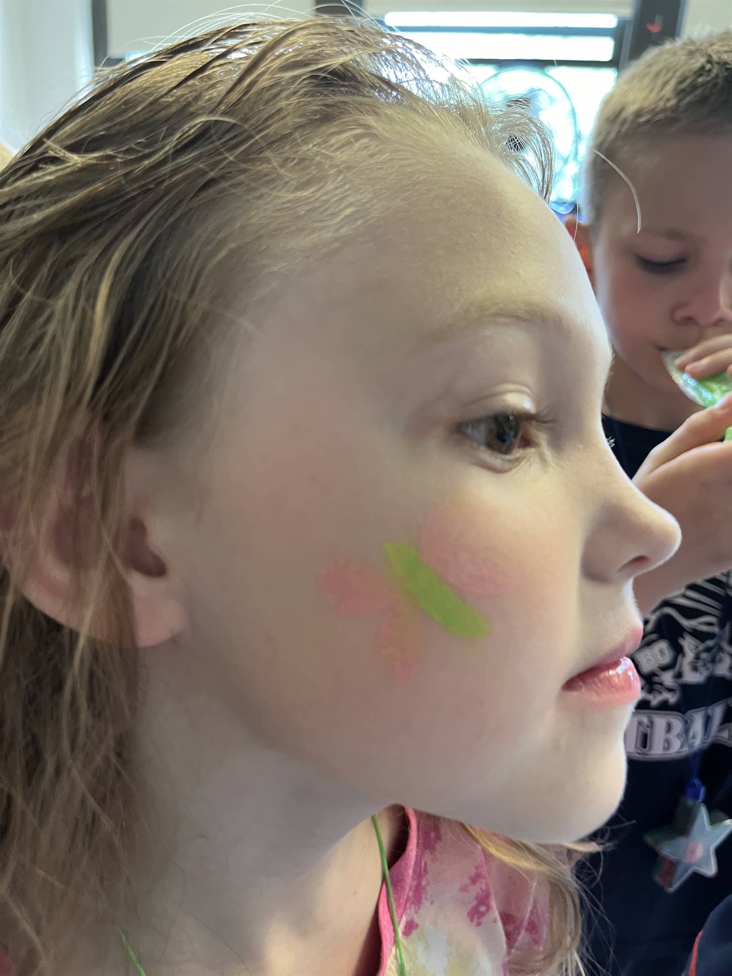 student with pink butterfly on her cheek.