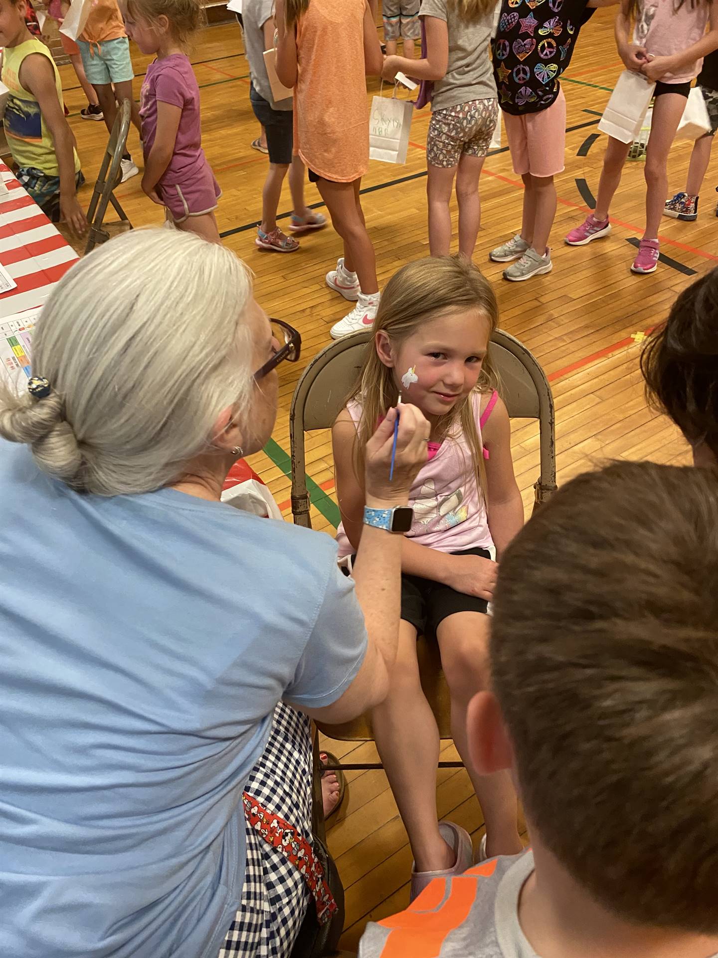 A face painting artist paints a students' face.