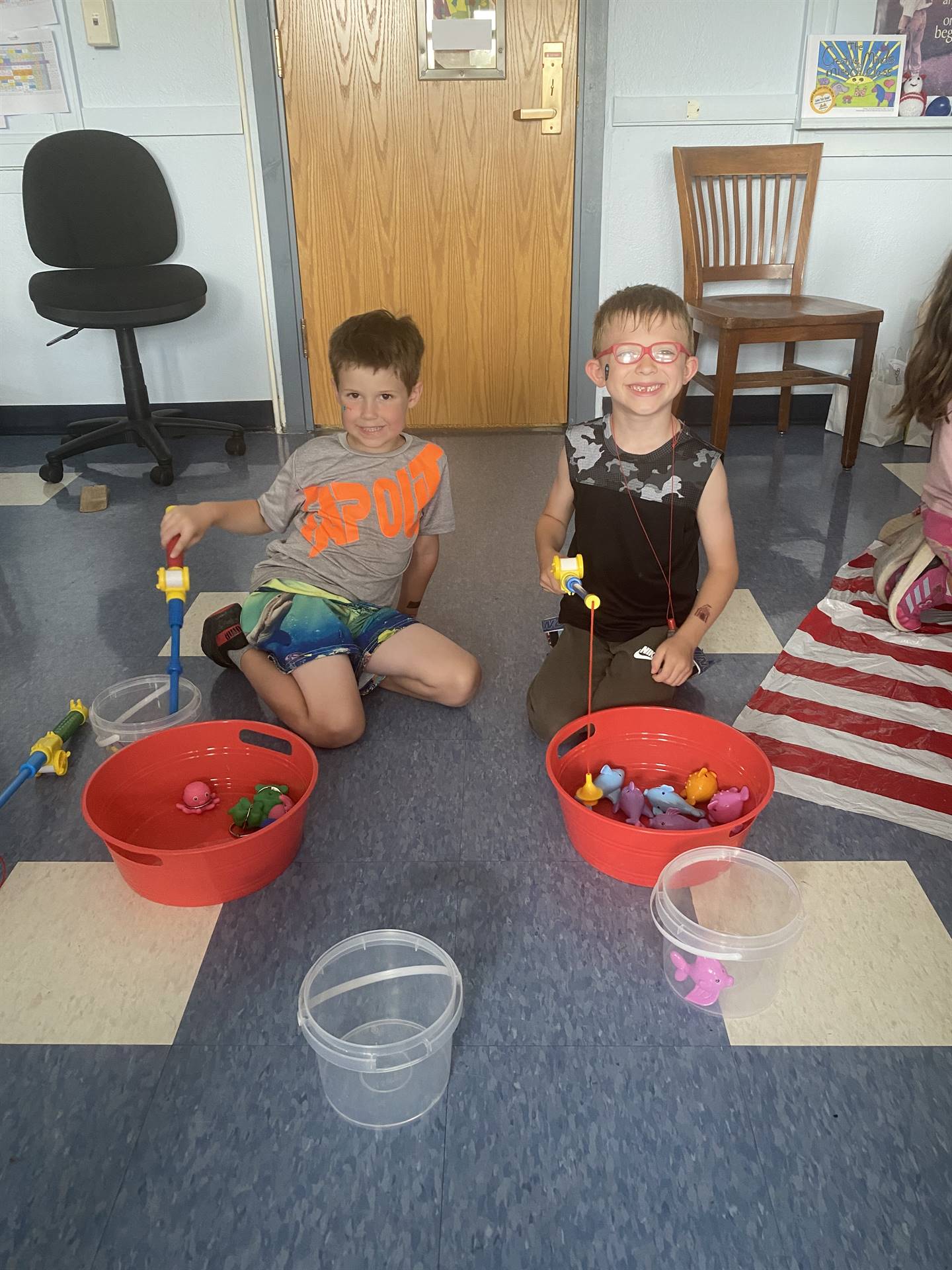 students pretend fishing out of red buckets.
