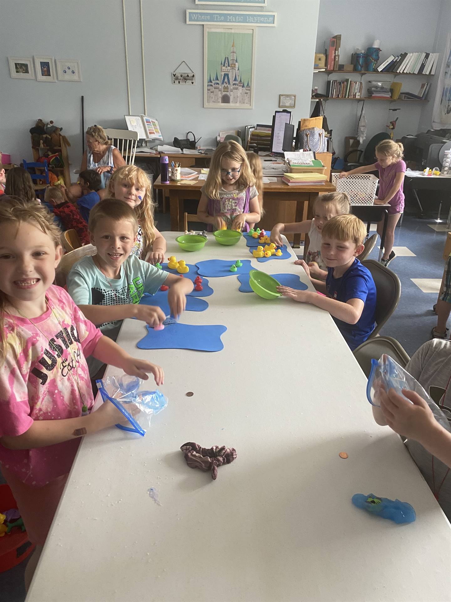 students pour sand out of a bottle to make a sand art craft. 