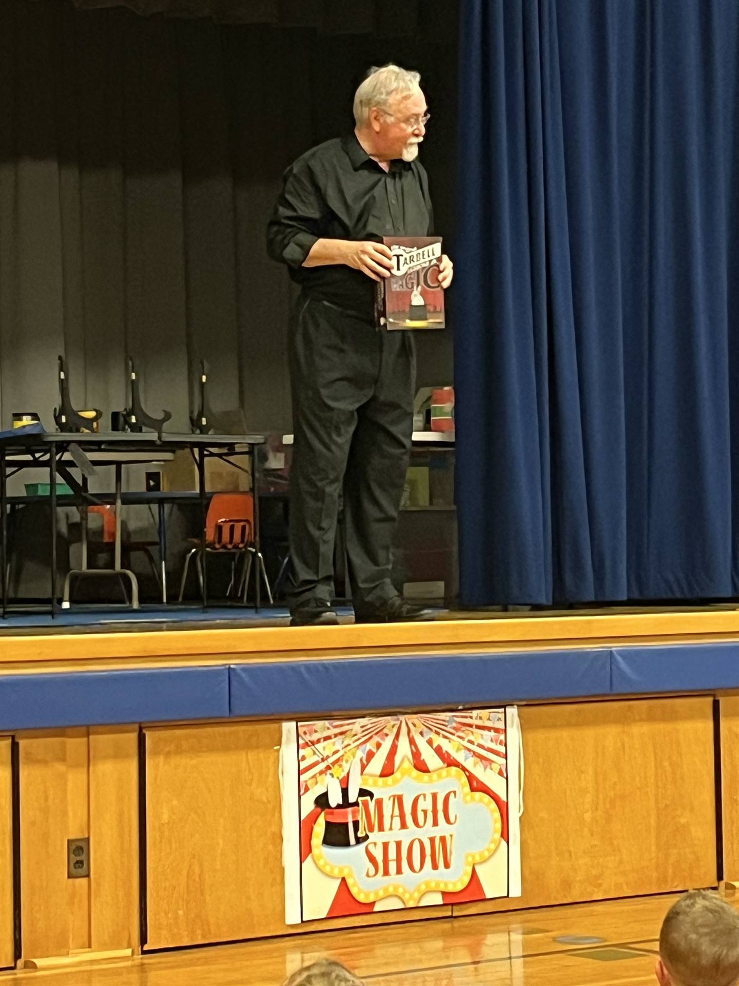 a Magician dressed in black shows his magic book