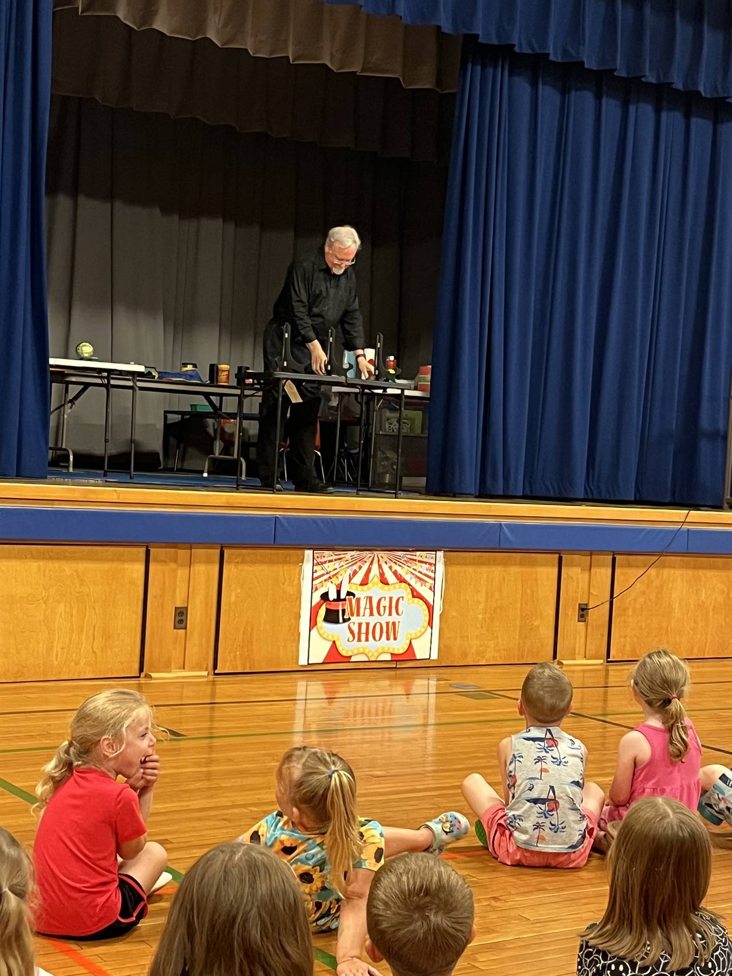 a Magician dressed in black performs a magic trick