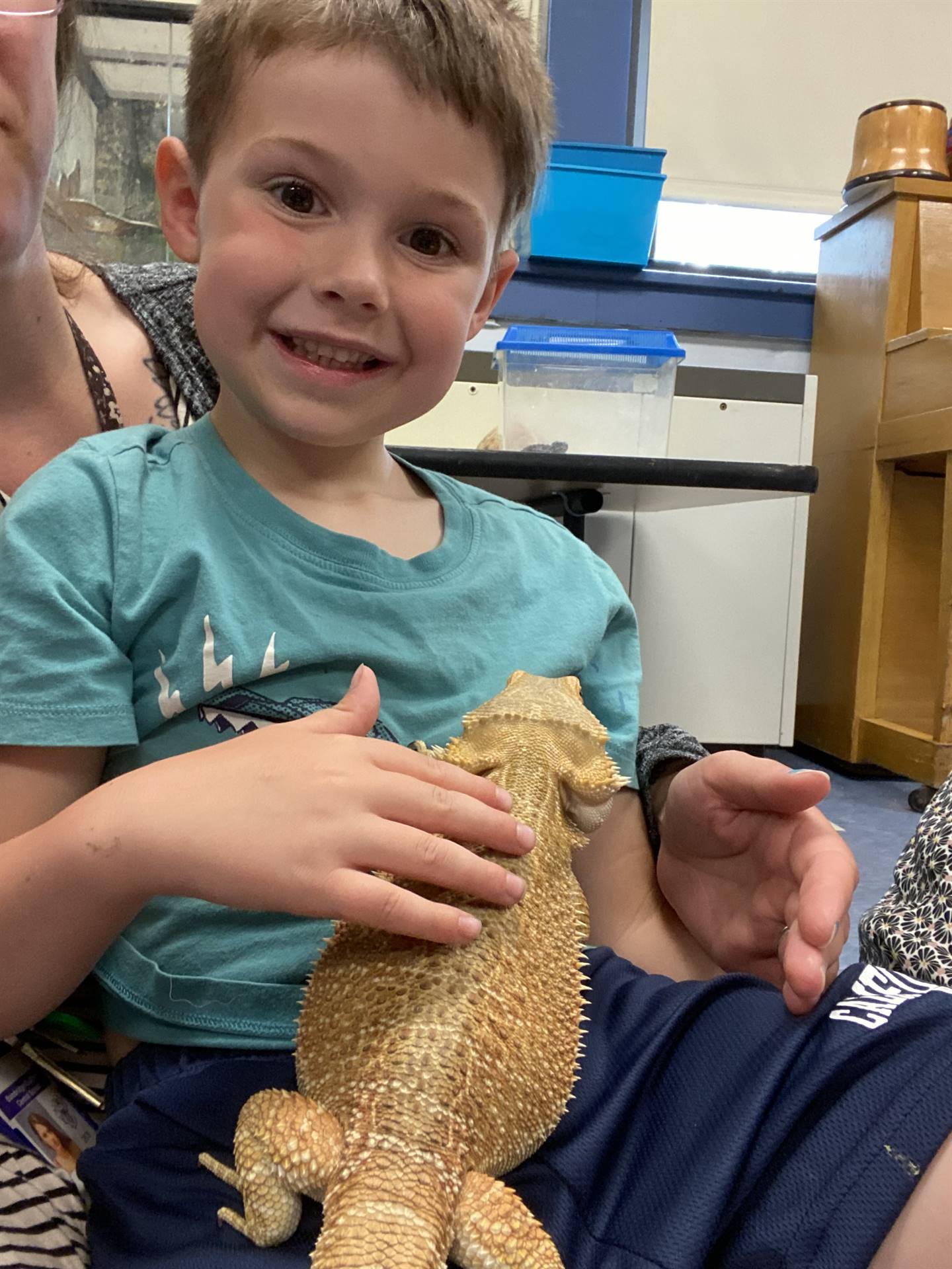 A student pets and holds a reptile lizard