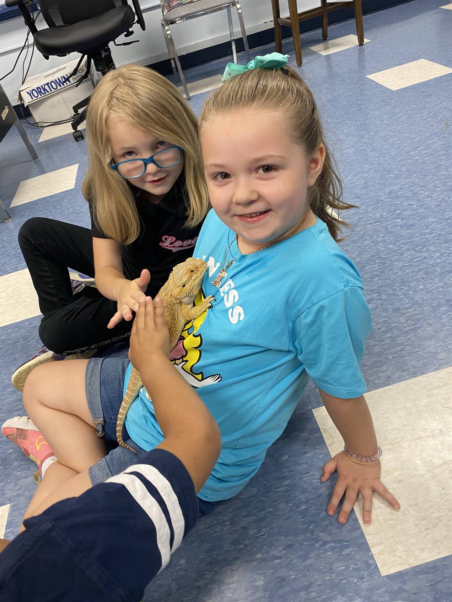 students pet and hold a reptile lizard