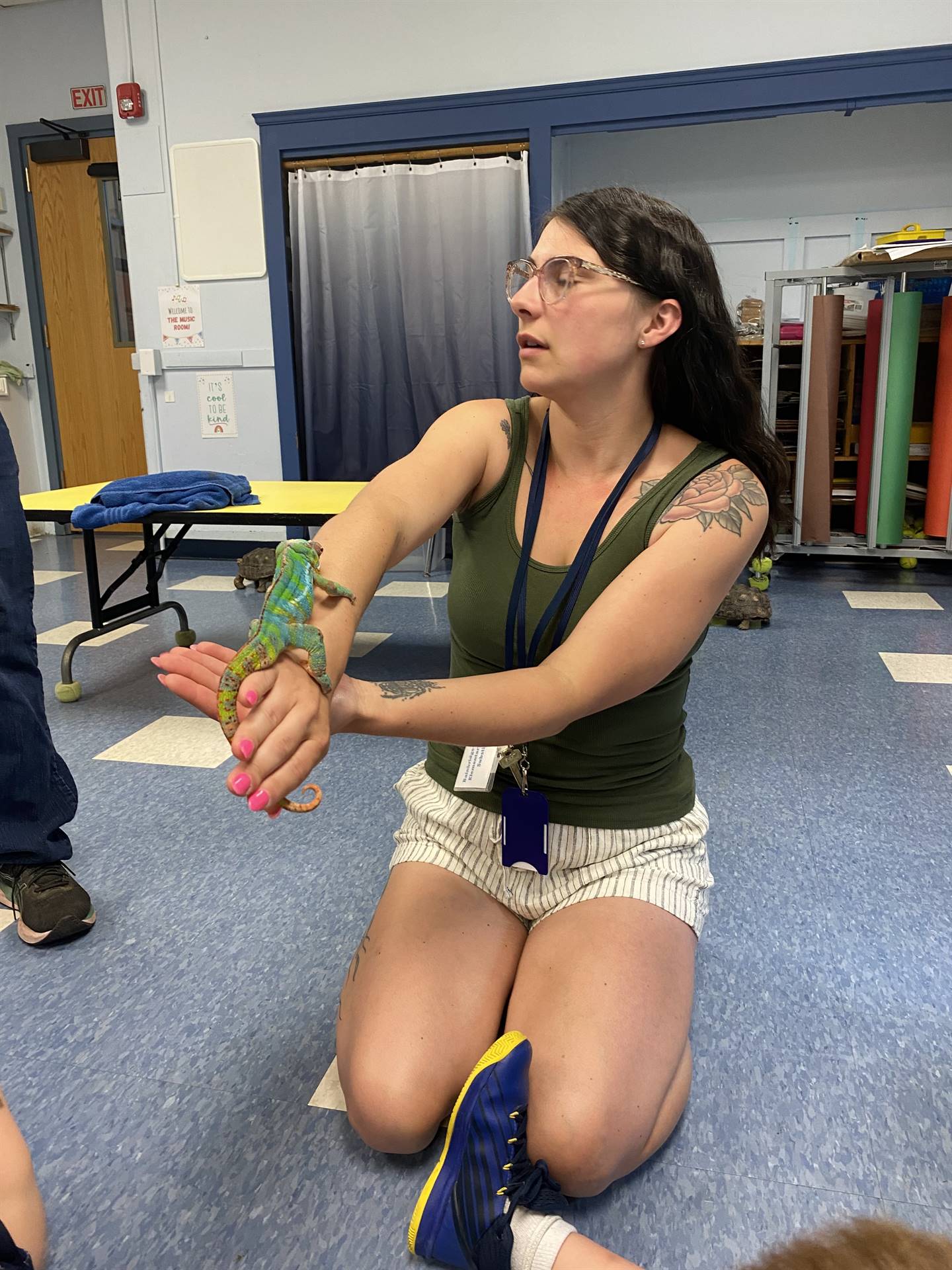 an adult holds a chameleon
