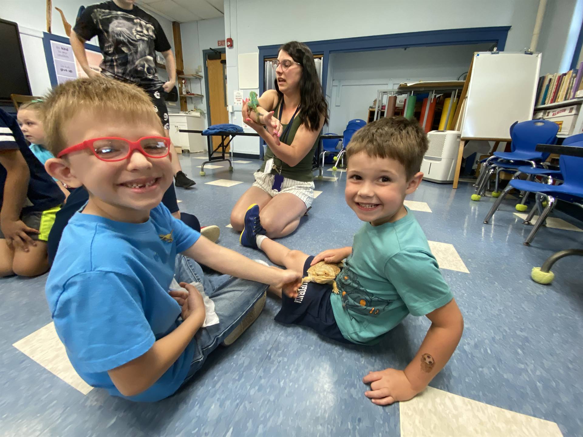students pet and hold a reptile lizard