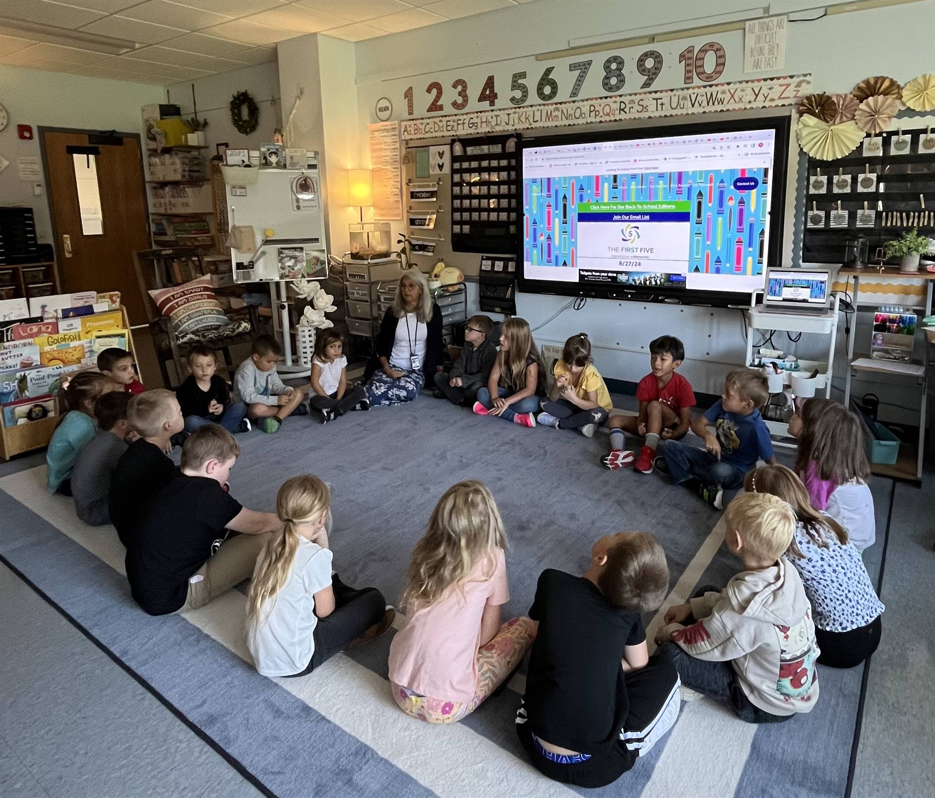 students sitting on circle on rug