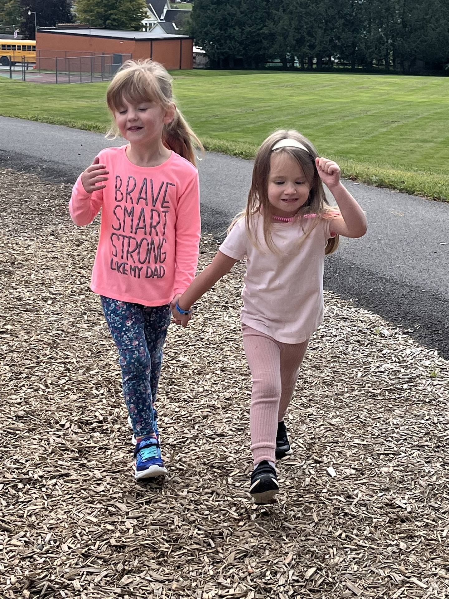 2 students standing outdoors holding hands
