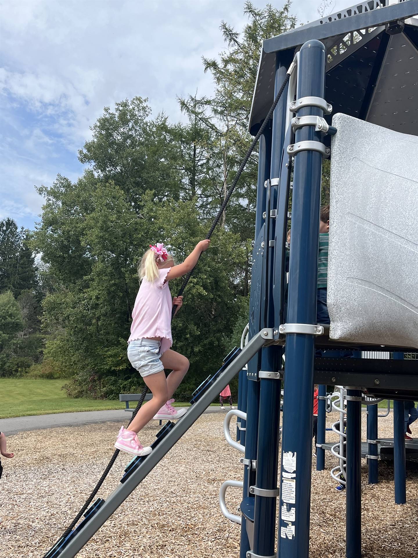 a student climbing up a ladder on playground