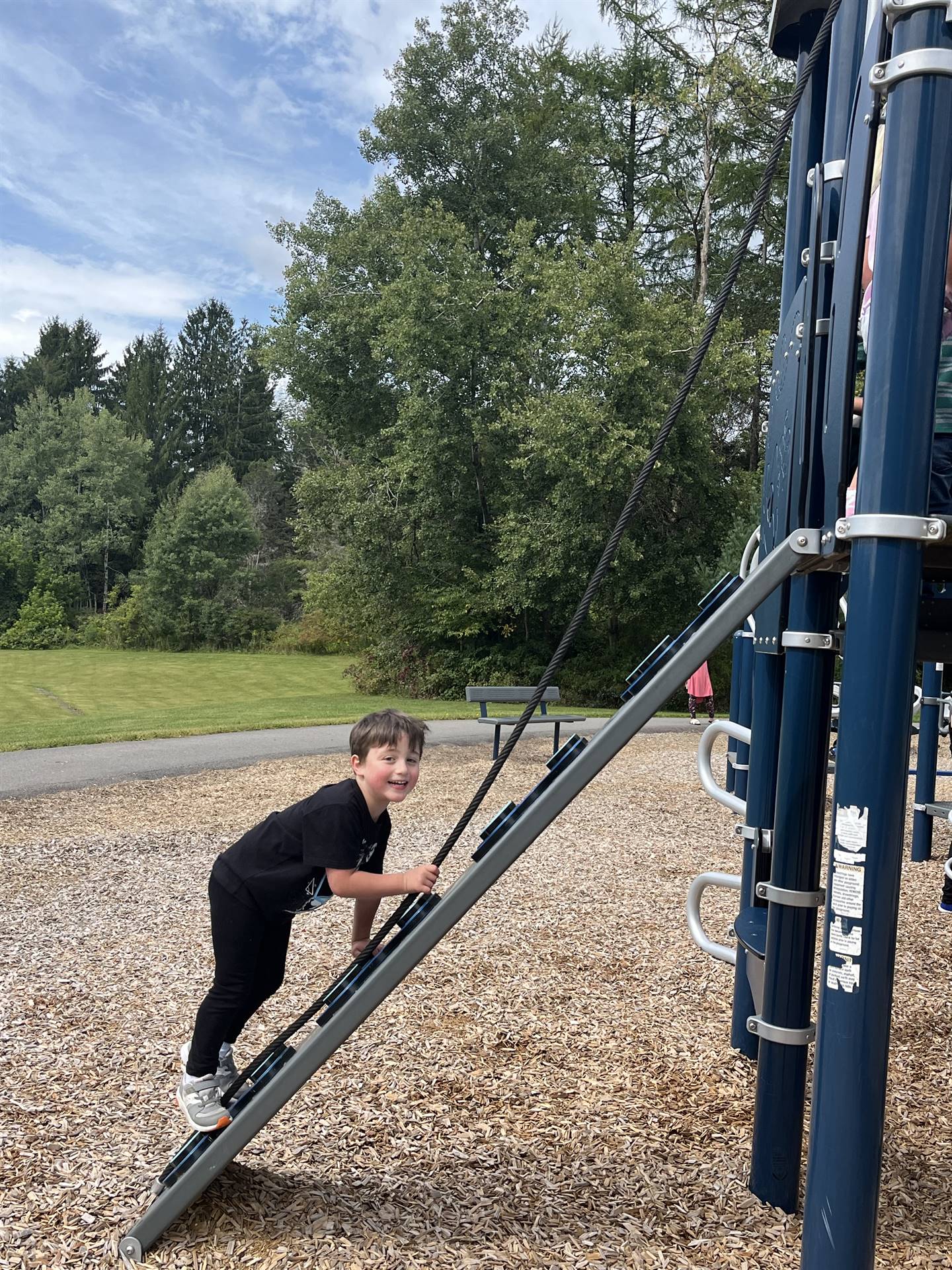 a student climbing up a ladder on playground