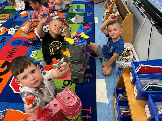 3 students holding up their toys
