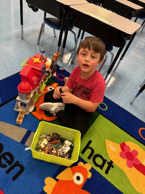 a student with a bin of toys playing