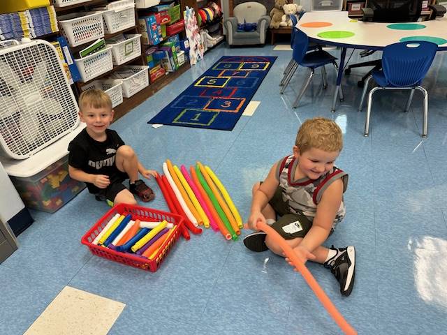 2 student playing on floor.