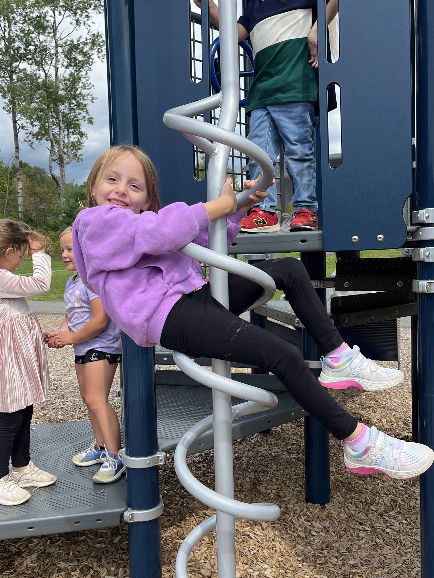 a student sliding down a spiral on playground