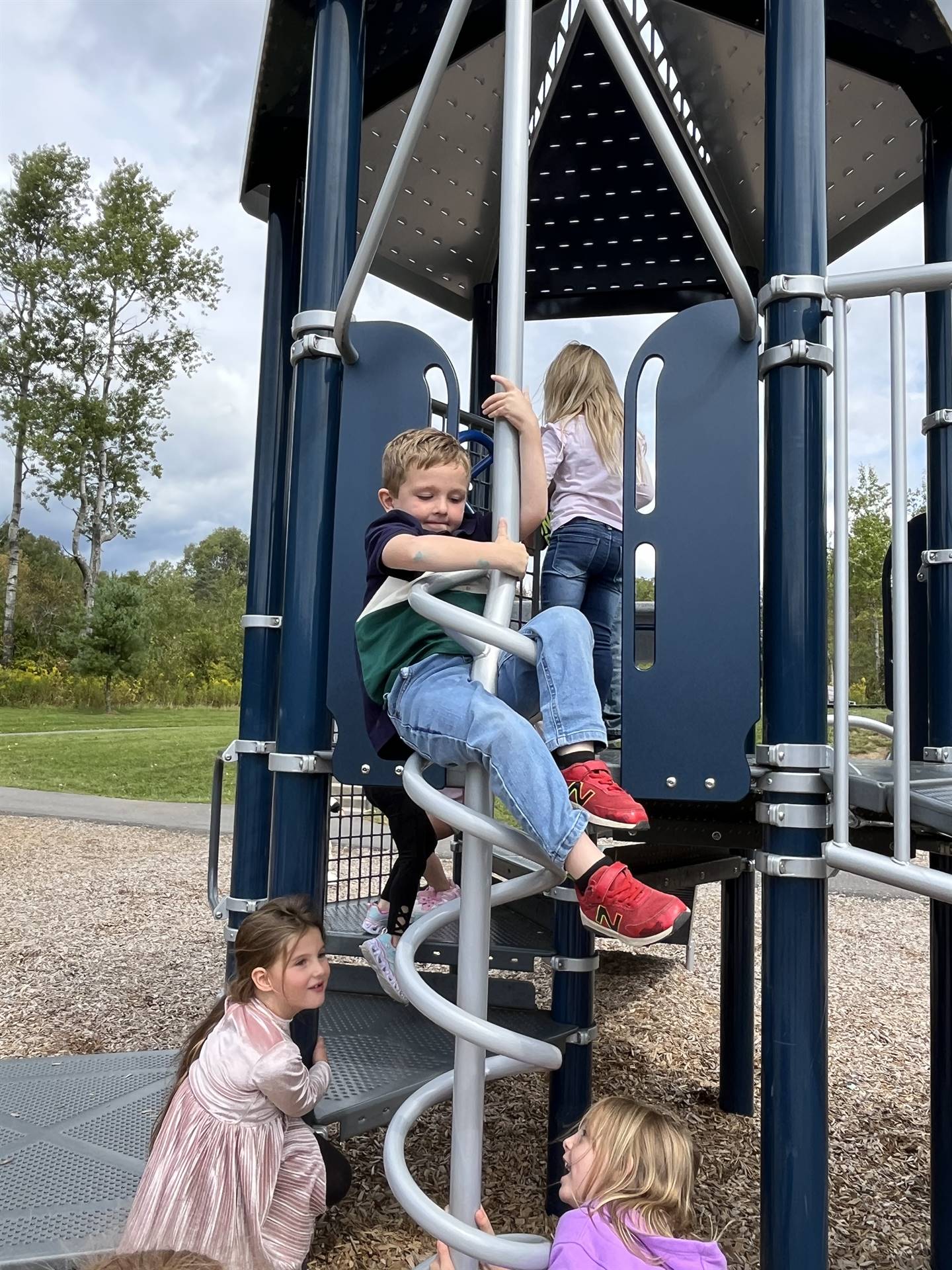 a student sliding down a spiral on playground