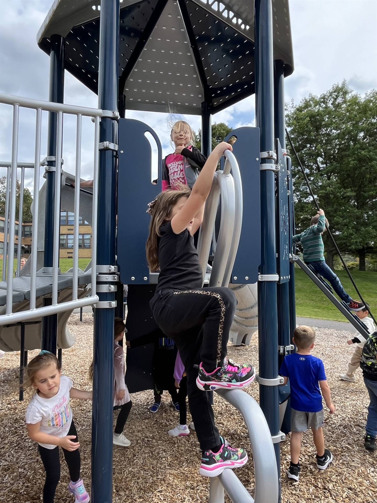 a student on monkey bars and other's watching