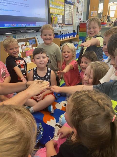 teacher with praying mantis on fingers and students watching