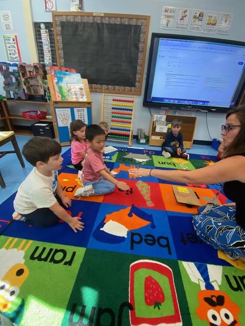 teacher with praying mantis on fingers and students watching
