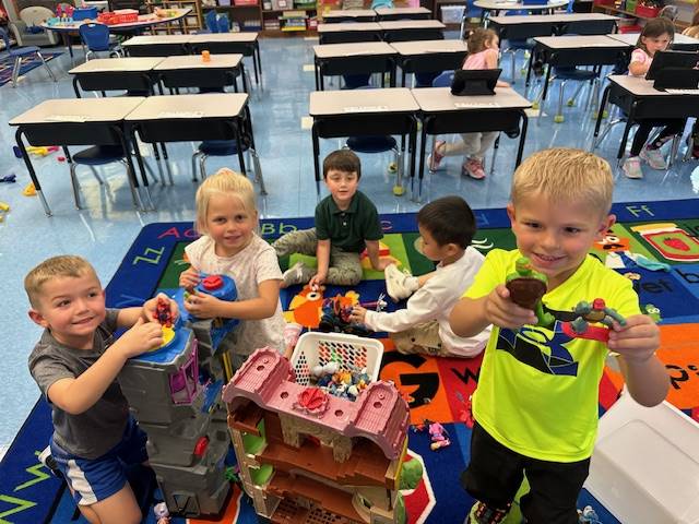 a group of students are playing with a variety of toys.