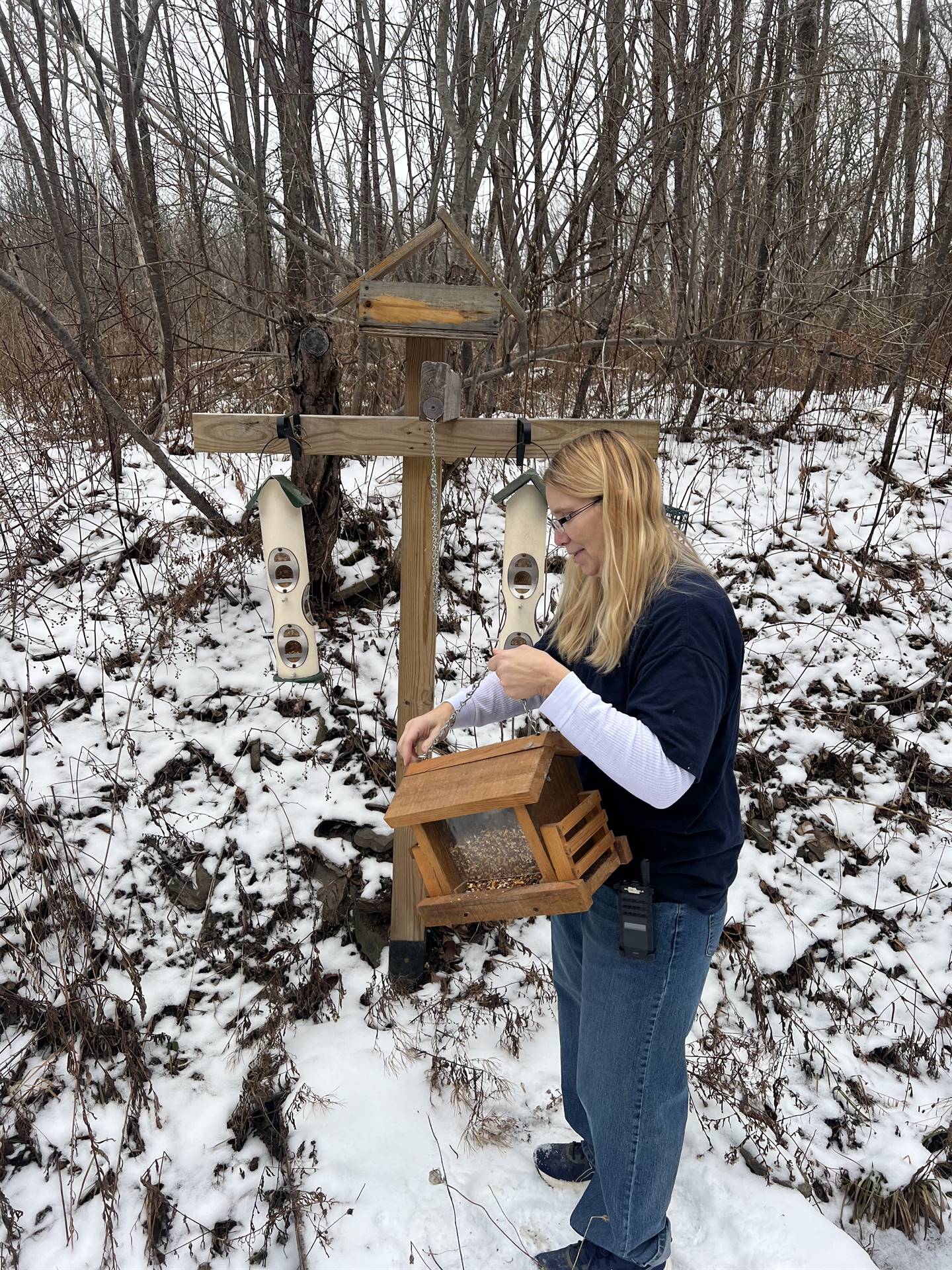 staff member filling a bird feeder