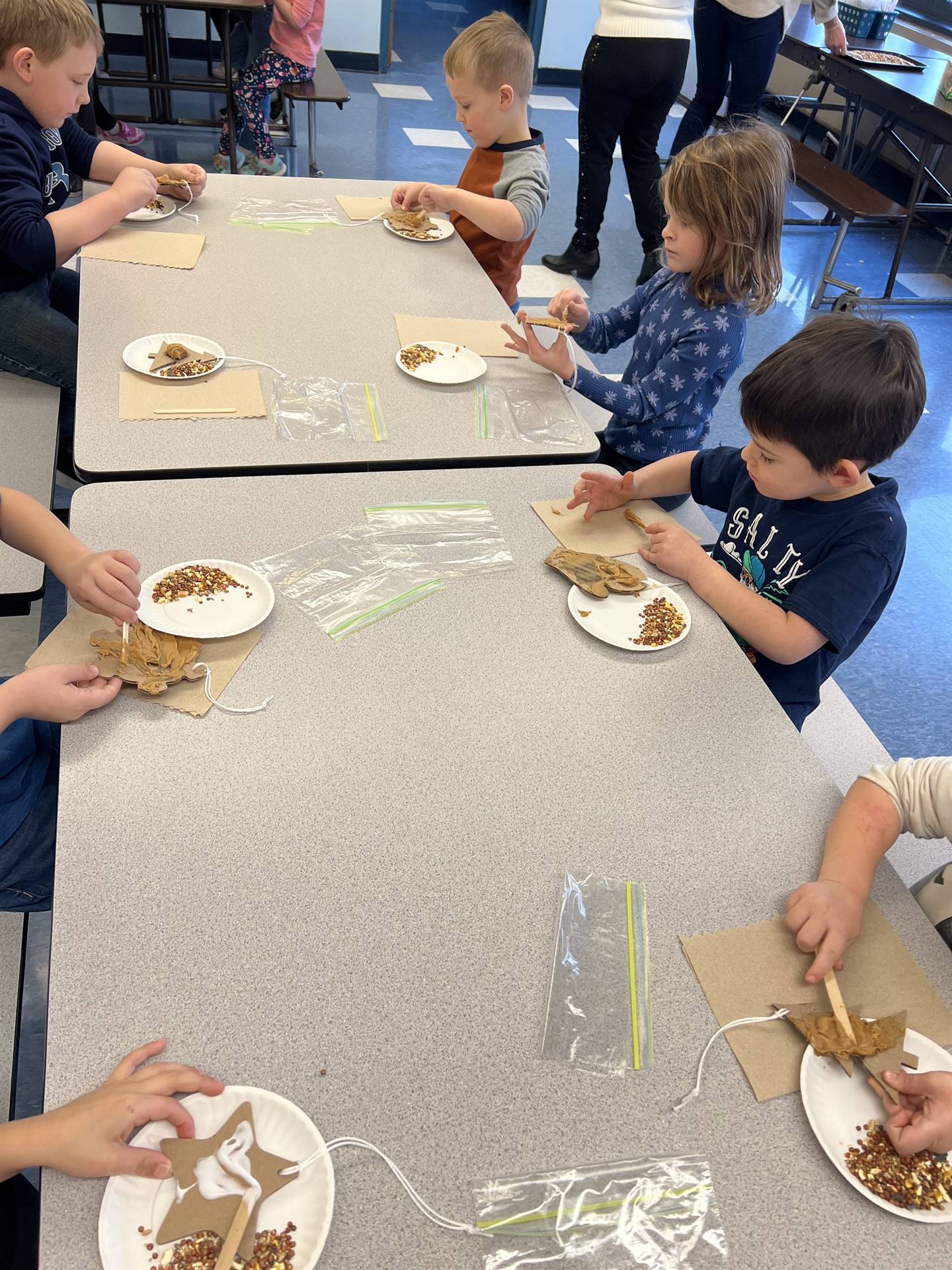 students spreading peanut butter on shapes.