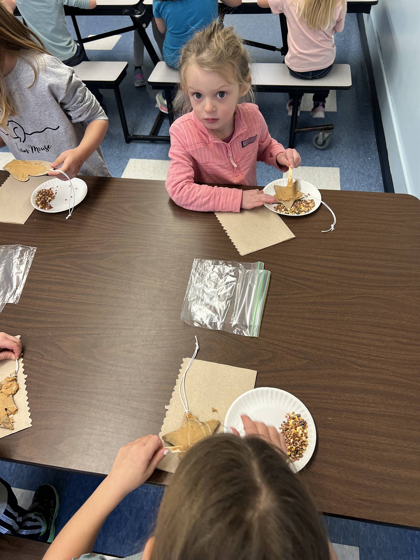 students spreading peanut butter on shapes.