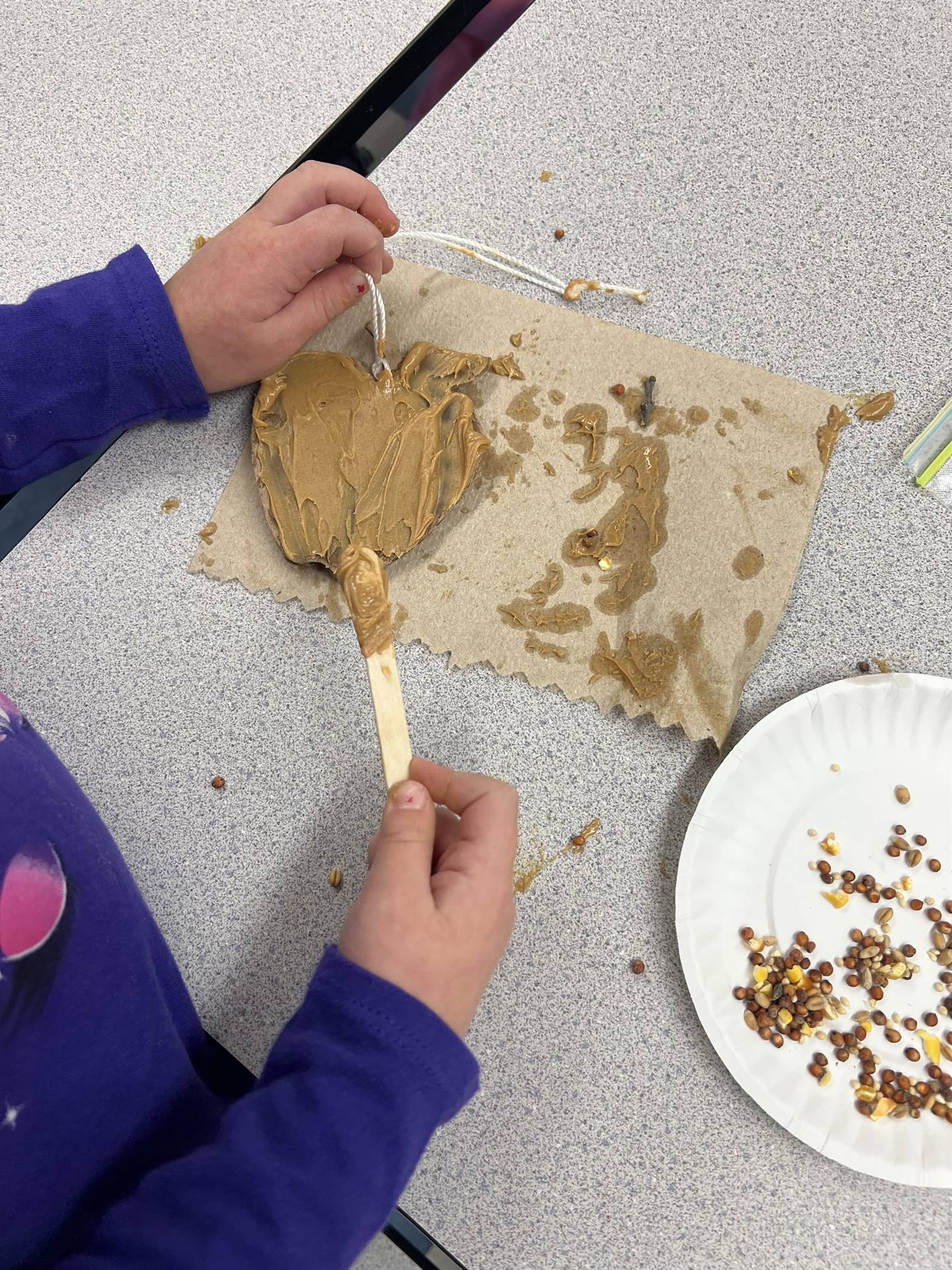 student spreads peanut butter on shapes.