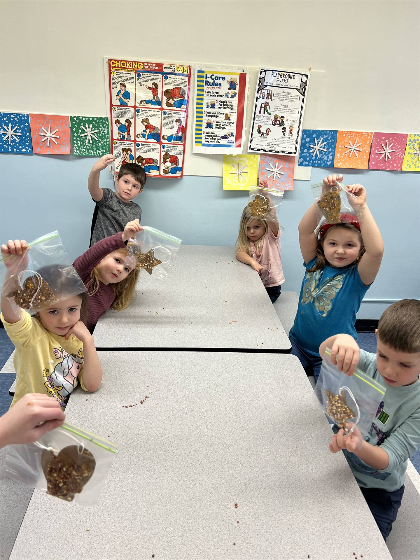 students hold up their completed bird feeder shapes!