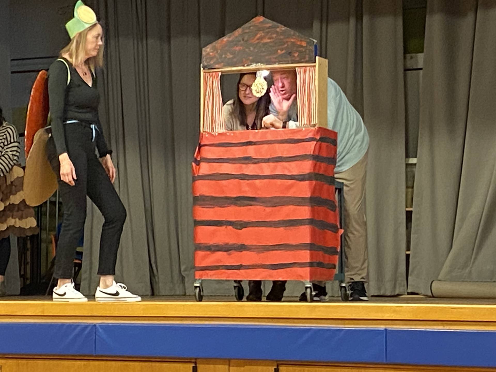  a dressed up firefly and a red house with black stripes with 2 people