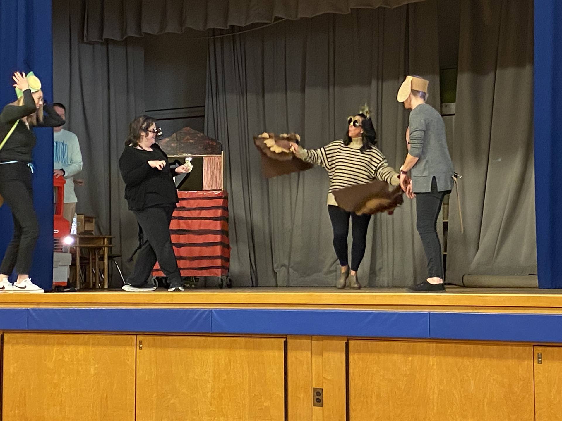 A black cat, owl, and puppy dog on stage