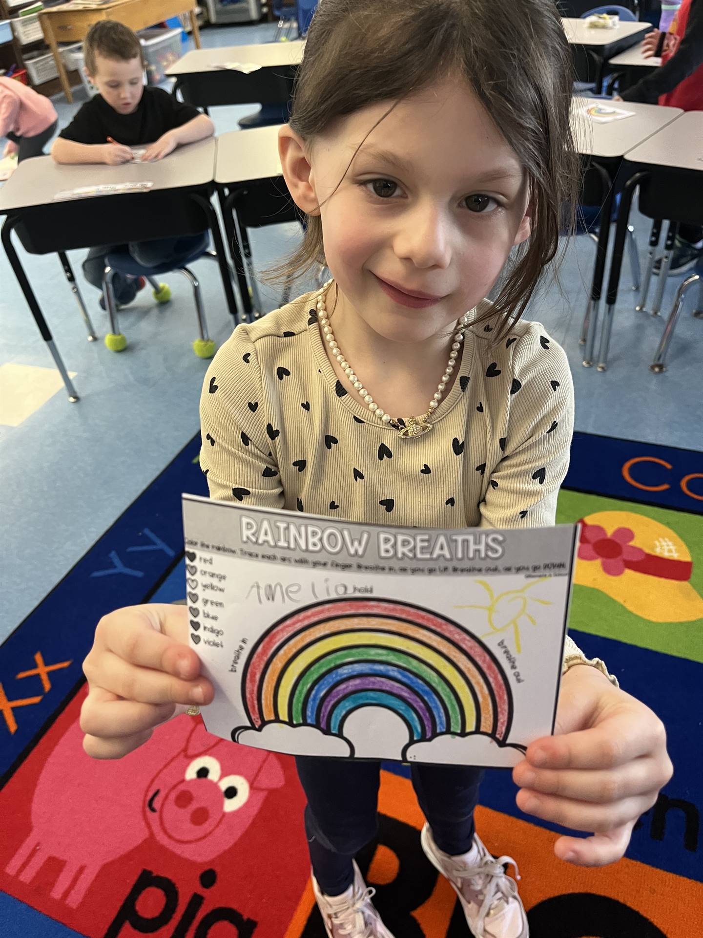 A student holds up a colored rainbow breathing guide
