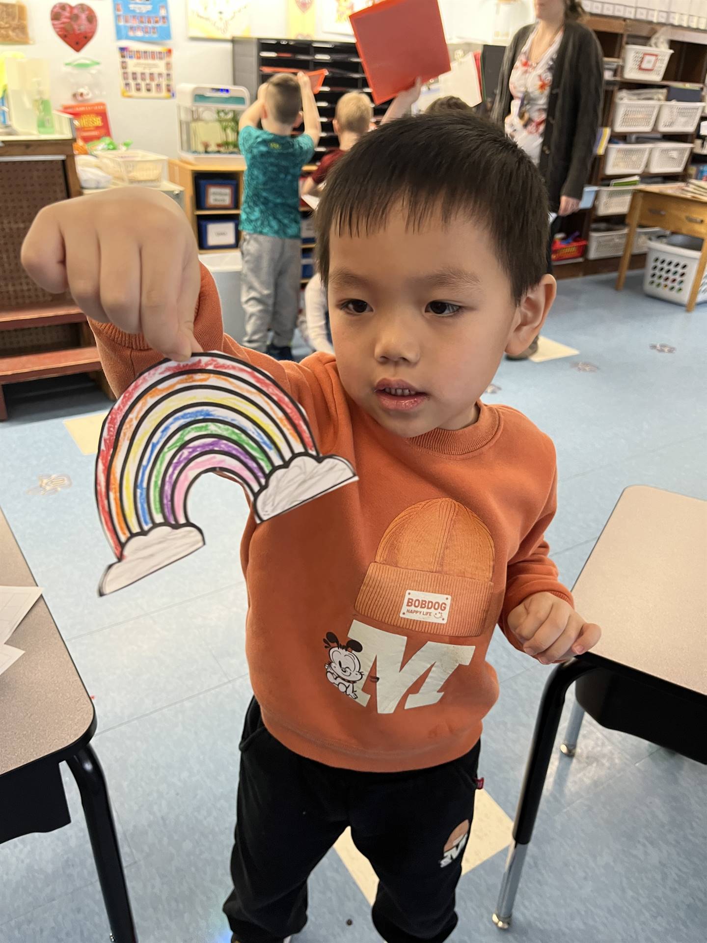A student holds up a colored rainbow breathing guide