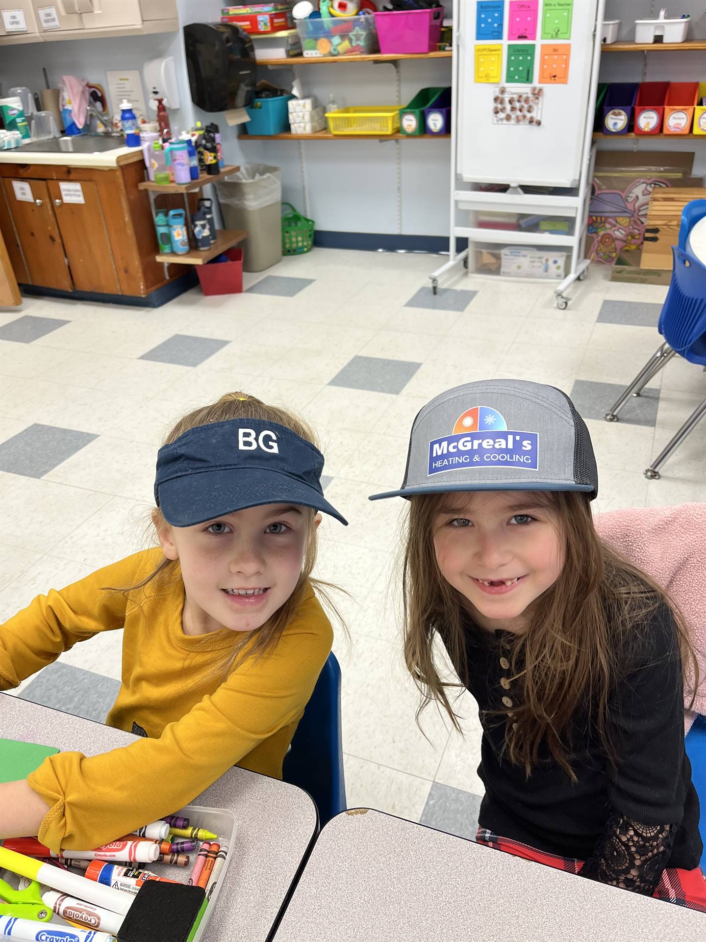 2 students with baseball cap on each.