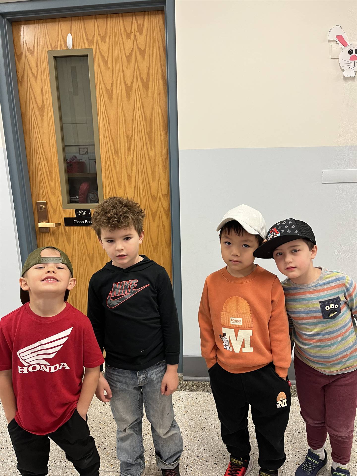 4 students with baseball caps on their head.